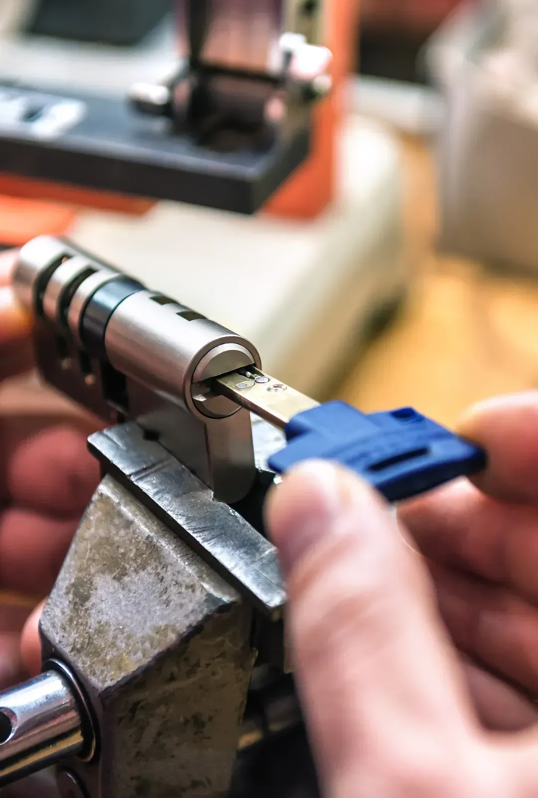 A person is working on a lock with a blue key.