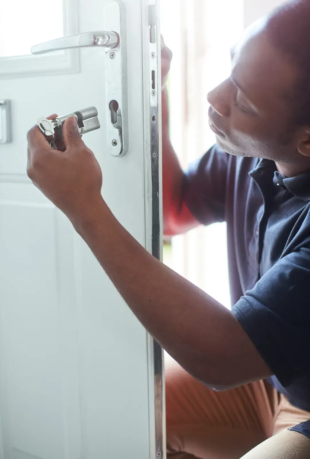 A man is fixing a door with a key.