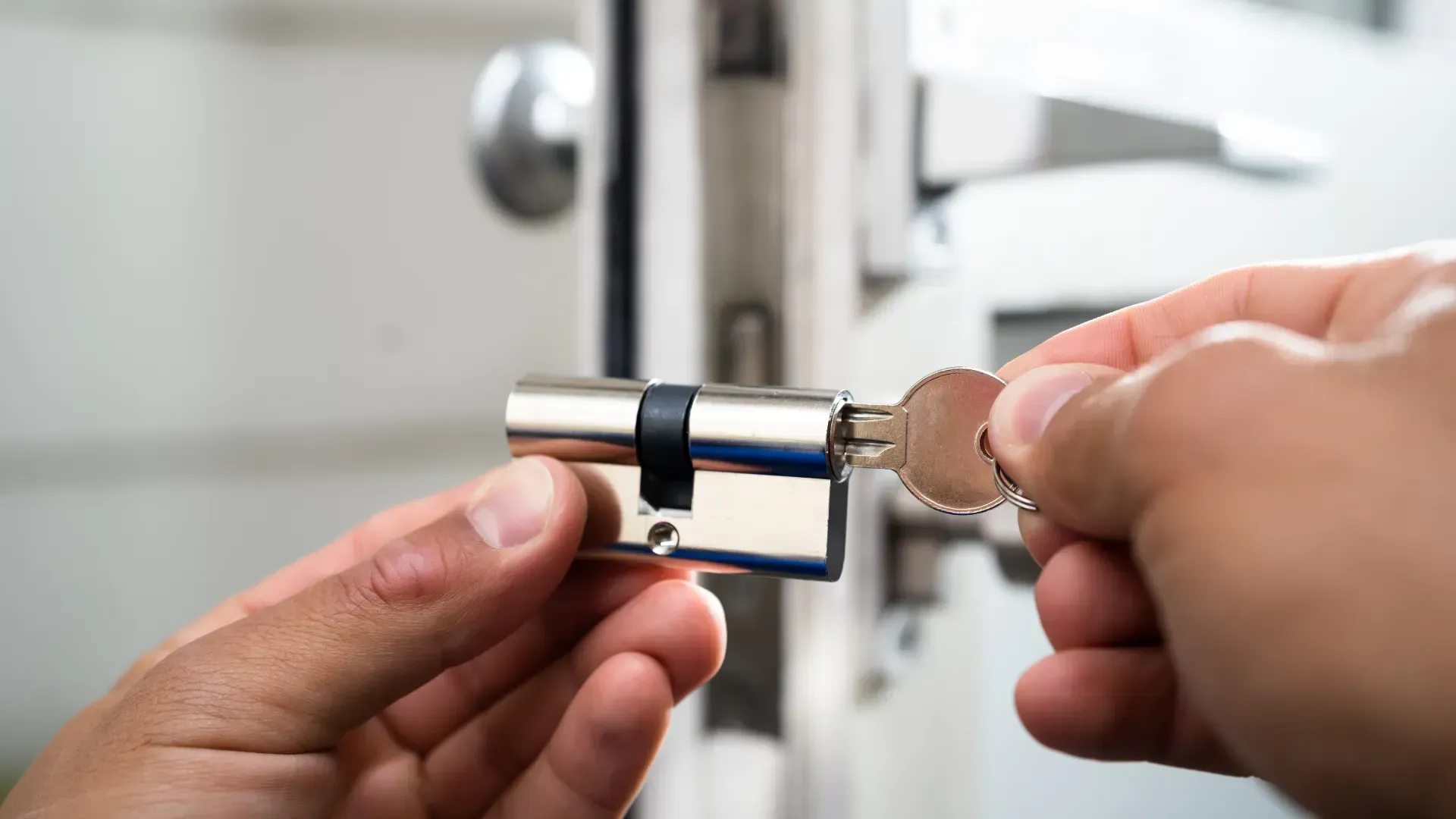 A person is holding a key in a key cylinder.