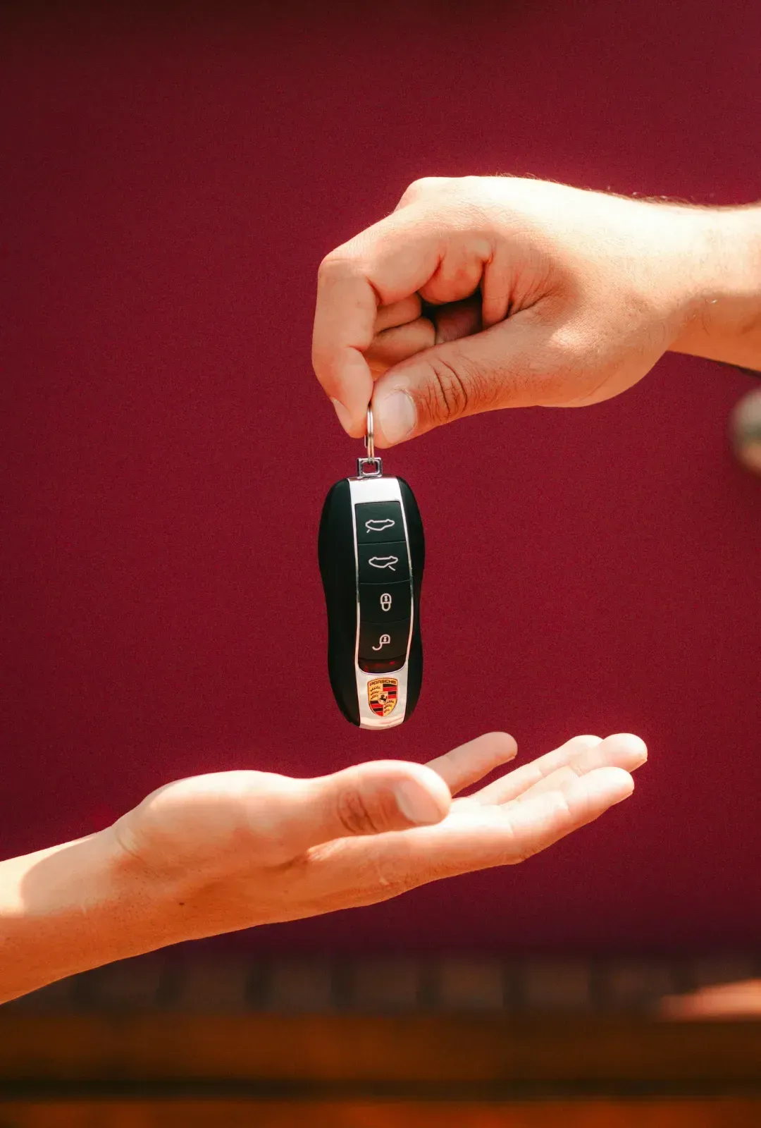 A person is handing a car key to another person.