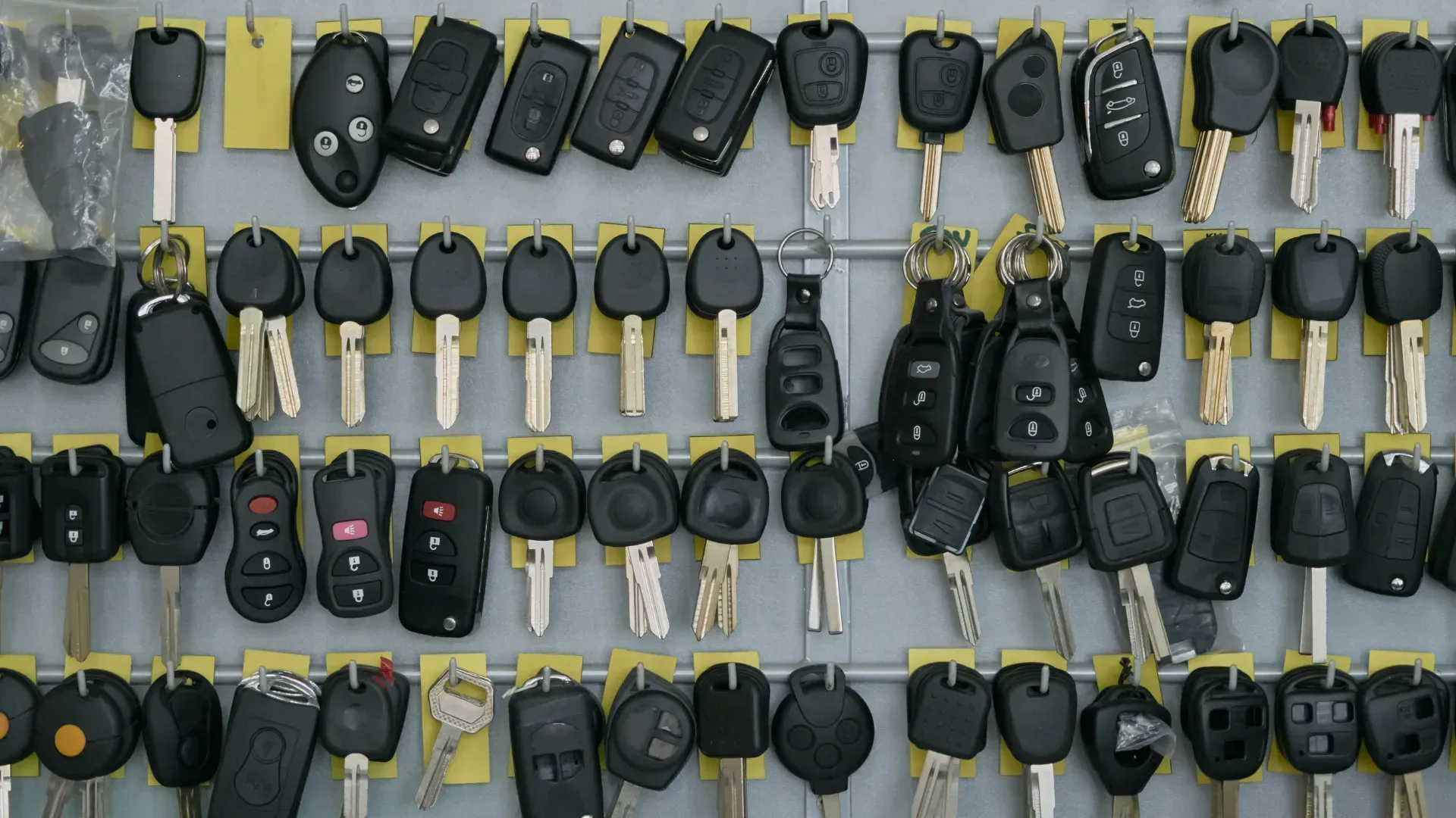 A bunch of car keys are hanging on a wall