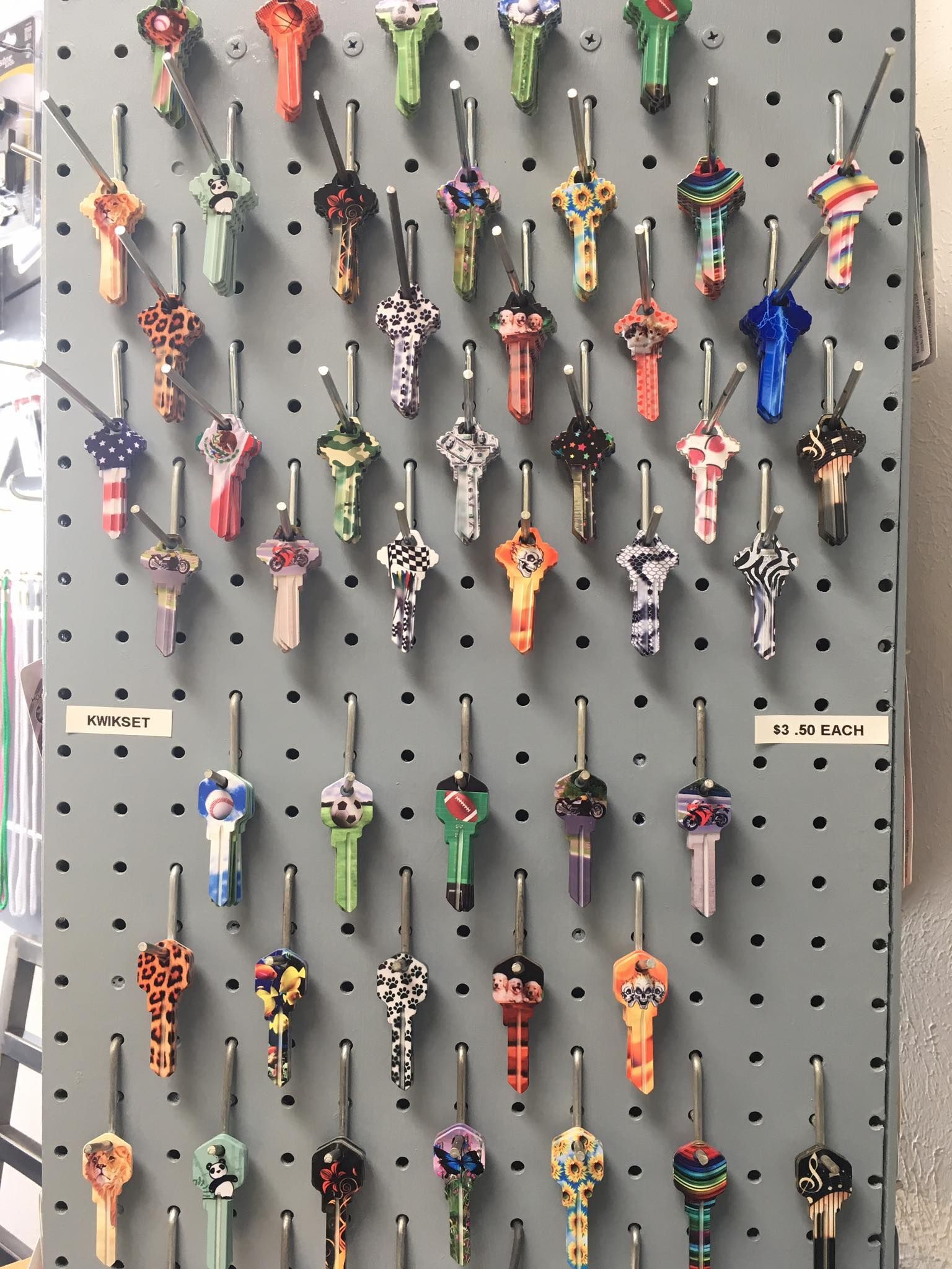 A bunch of colorful keys are hanging on a wall