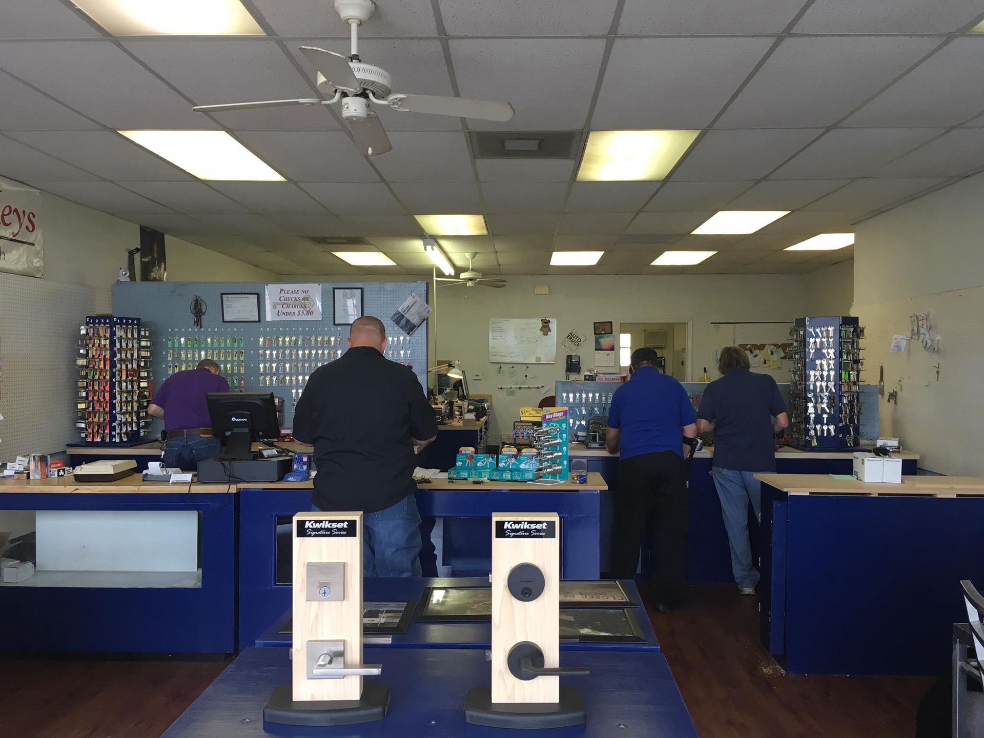 A group of men are standing at a counter in a store.