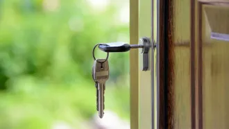 Two keys are hanging in a door lock.