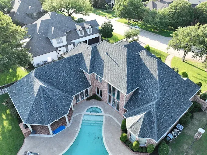 An aerial view of a large house with a pool in the backyard.