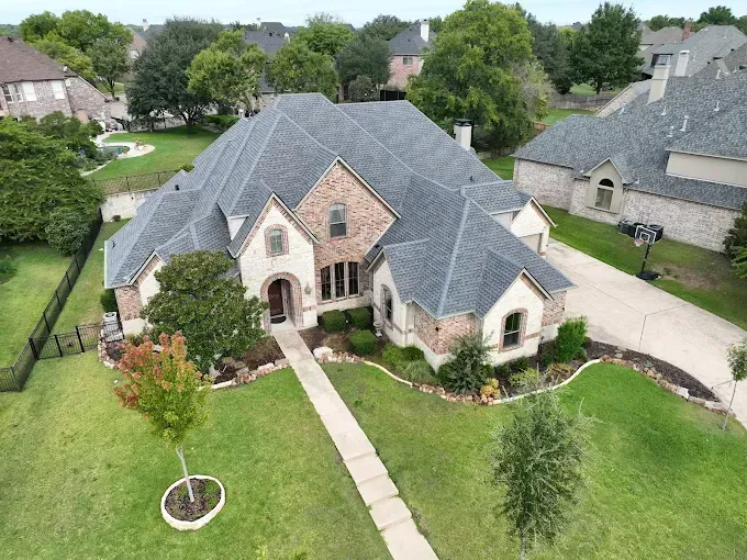 An aerial view of a large house with a gray roof