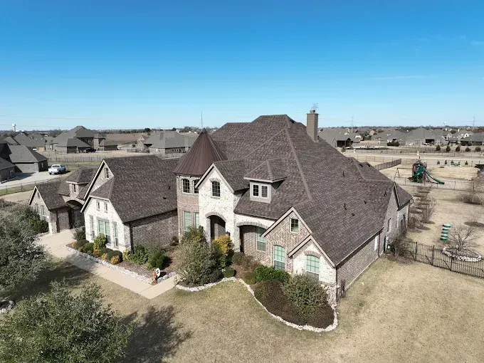 An aerial view of a large house in a residential area.