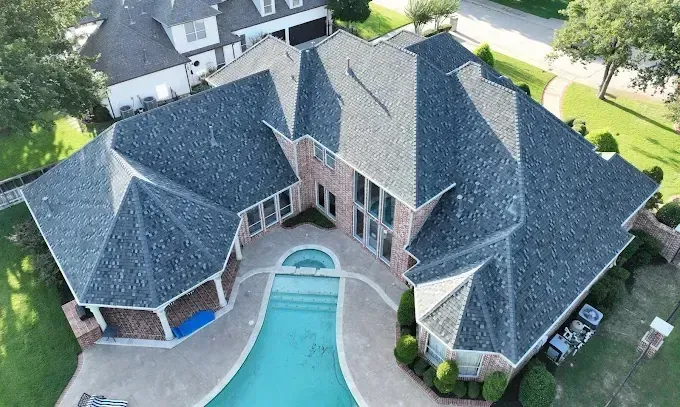 An aerial view of a large house with a pool in the backyard.