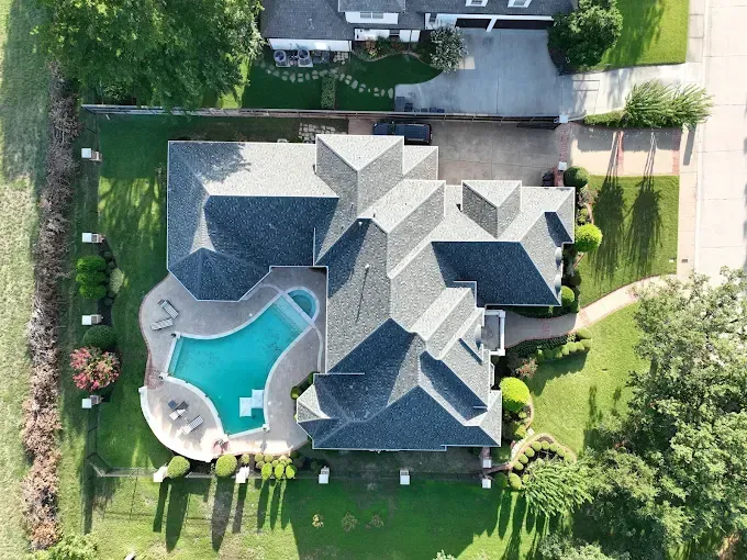 An aerial view of a house with a pool in the backyard