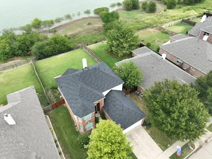 An aerial view of a house with a lake in the background.