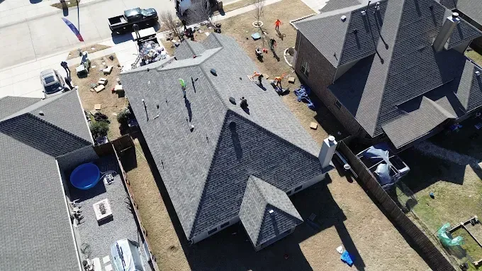 An aerial view of a house with a roof that is being repaired.