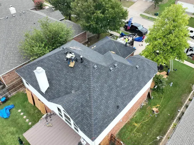An aerial view of a house with a new roof being installed.