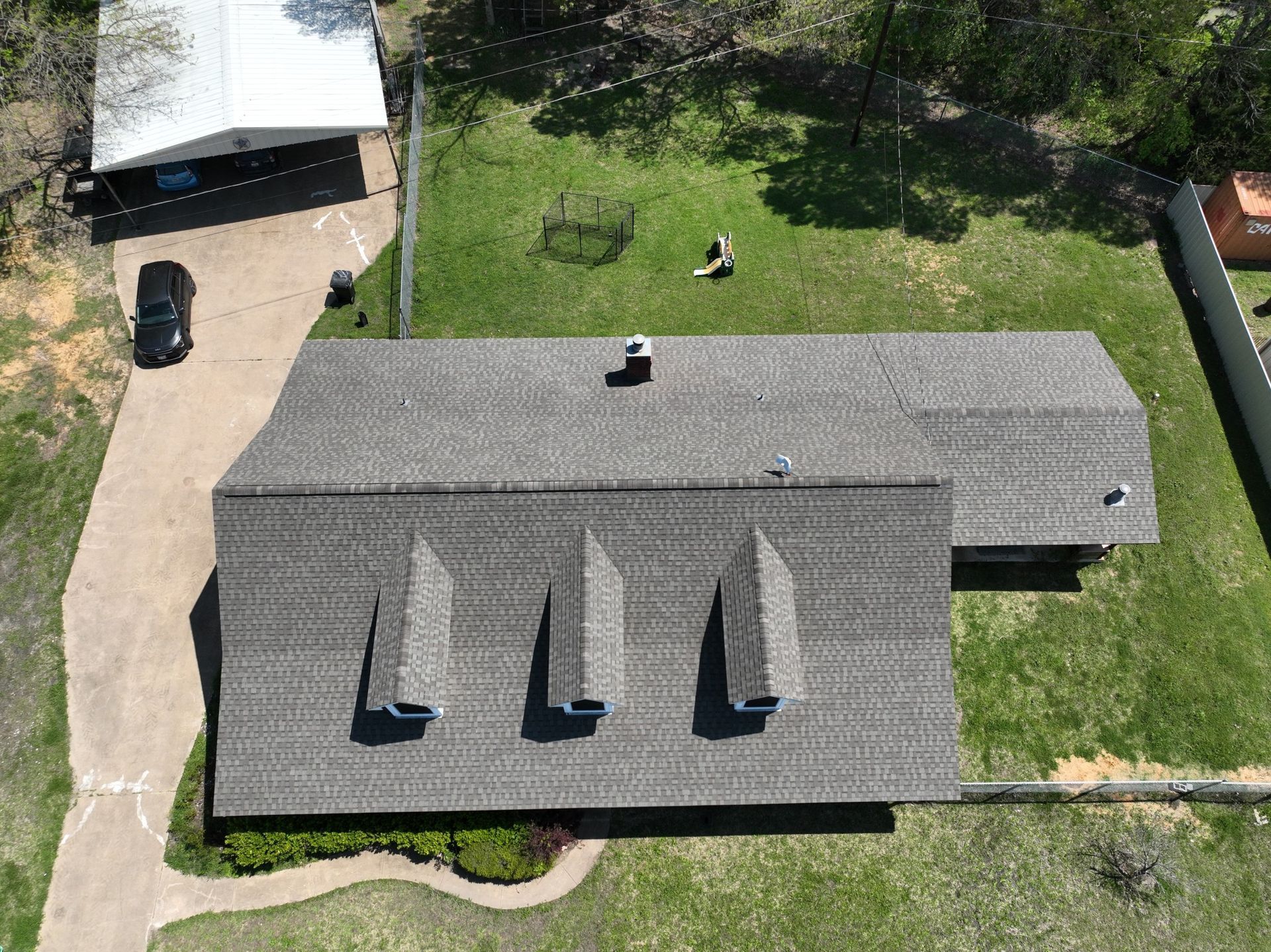 An aerial view of a house with a roof that has a lot of shingles on it.