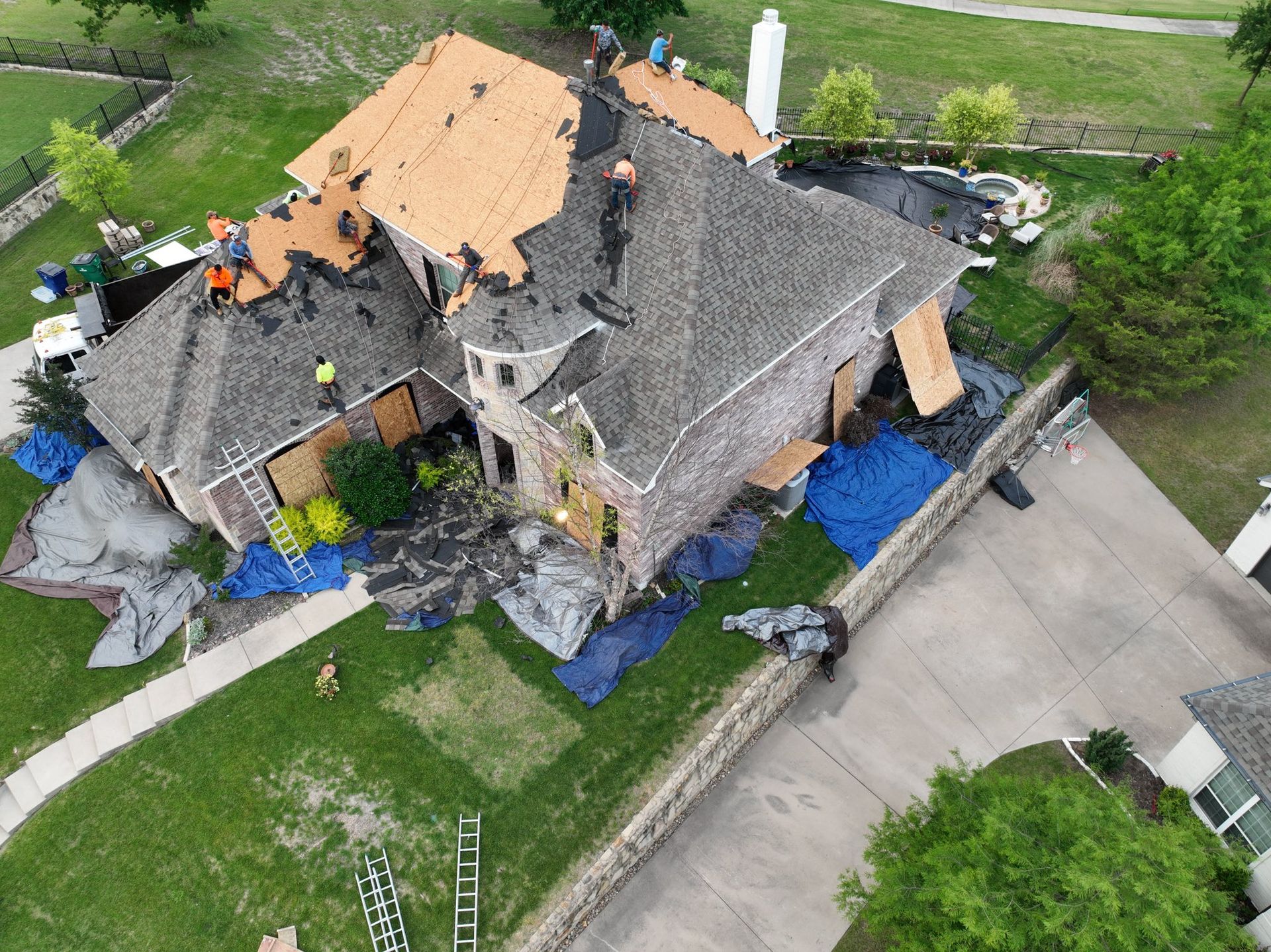 An aerial view of a house undergoing a roof replacement.