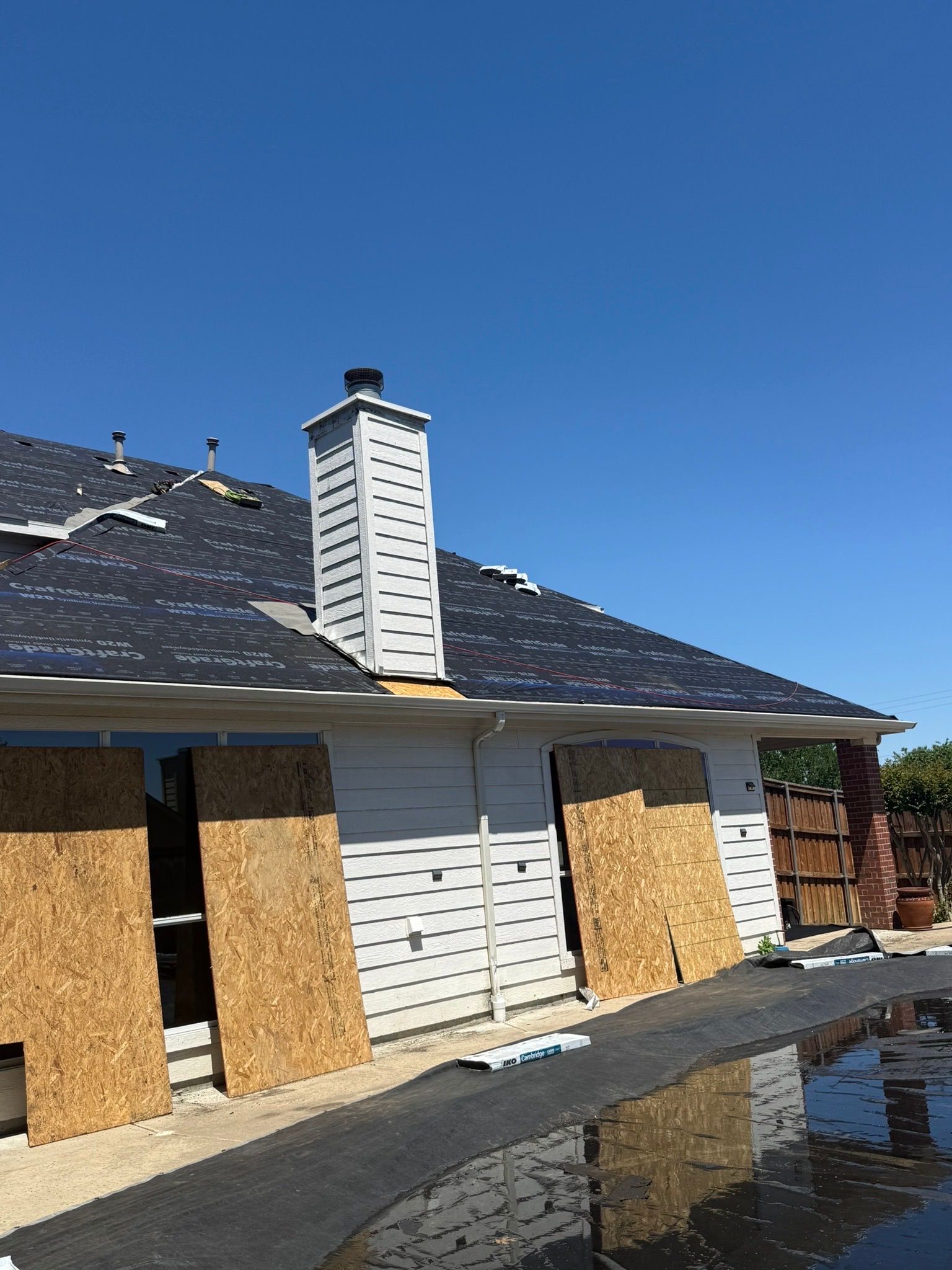 A house with a chimney on the roof is being remodeled.