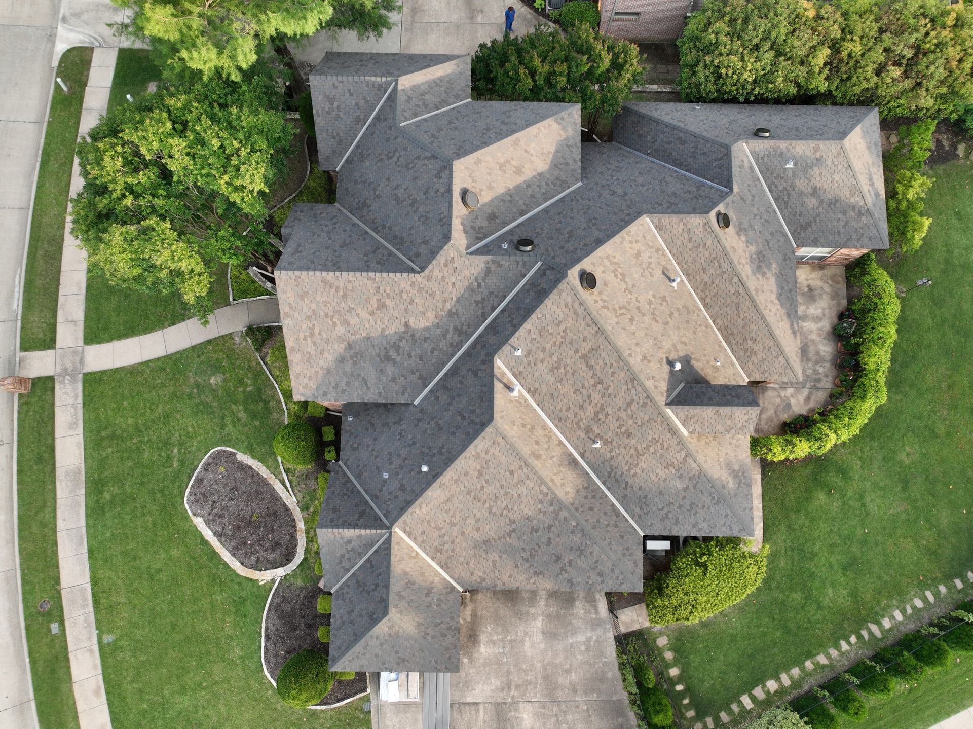 An aerial view of a large house with a lot of roofs.