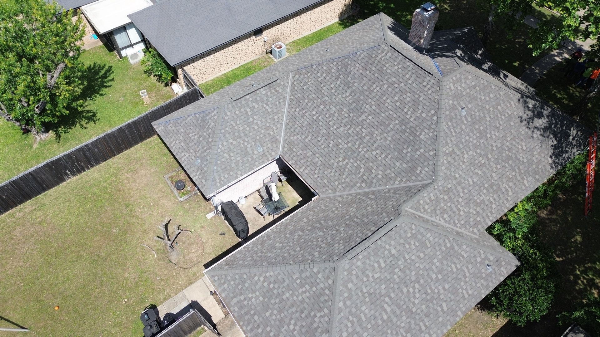 An aerial view of a house with a roof that is being repaired.