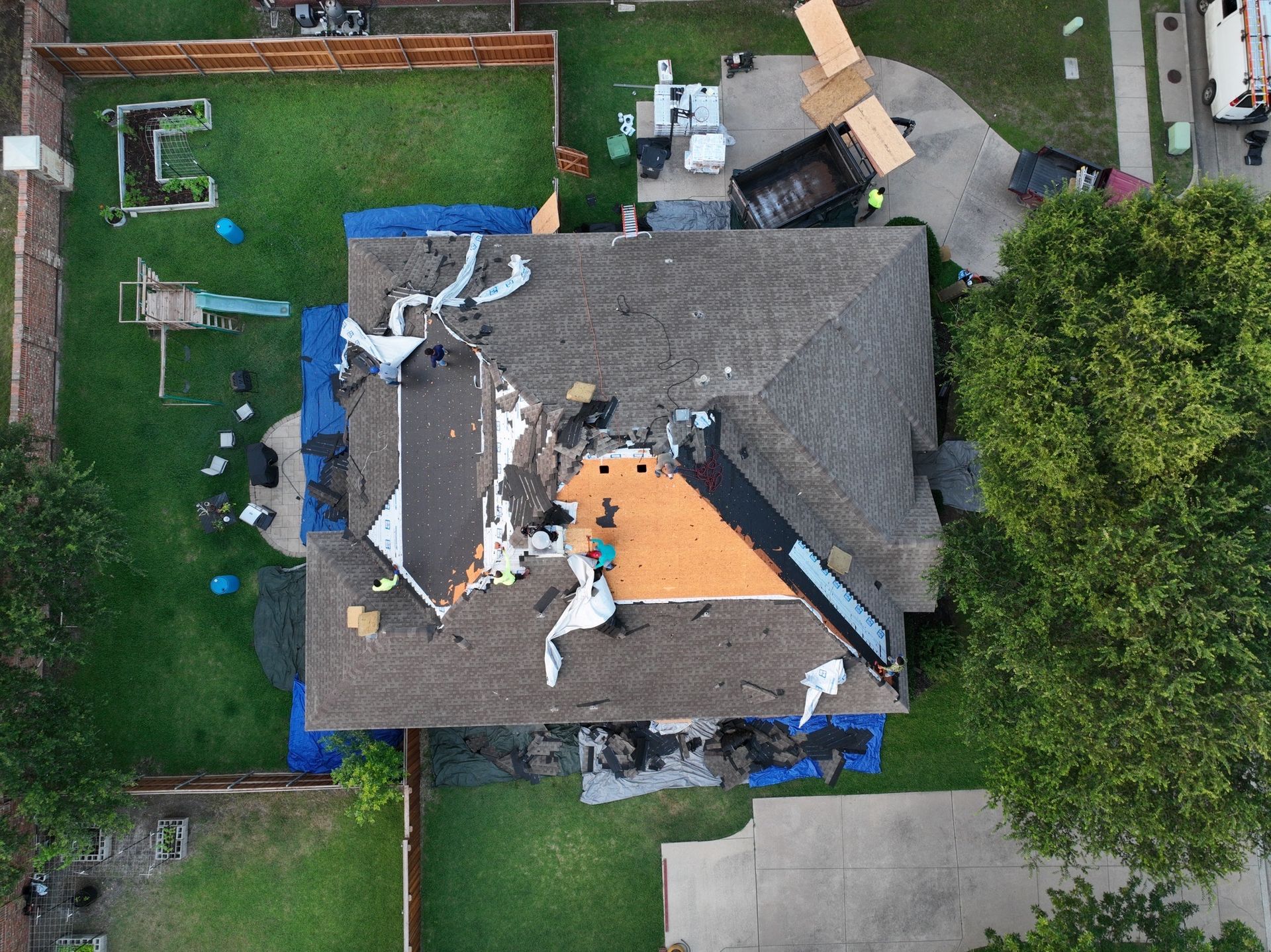 An aerial view of a house with a roof being repaired.