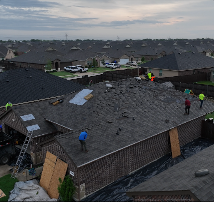 A group of people are working on the roof of a house