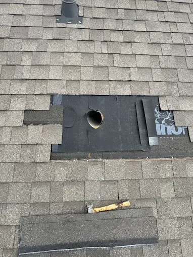 A roof with a hole in it and shingles missing.