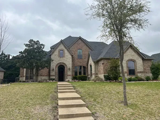 A large brick house with stairs leading up to it