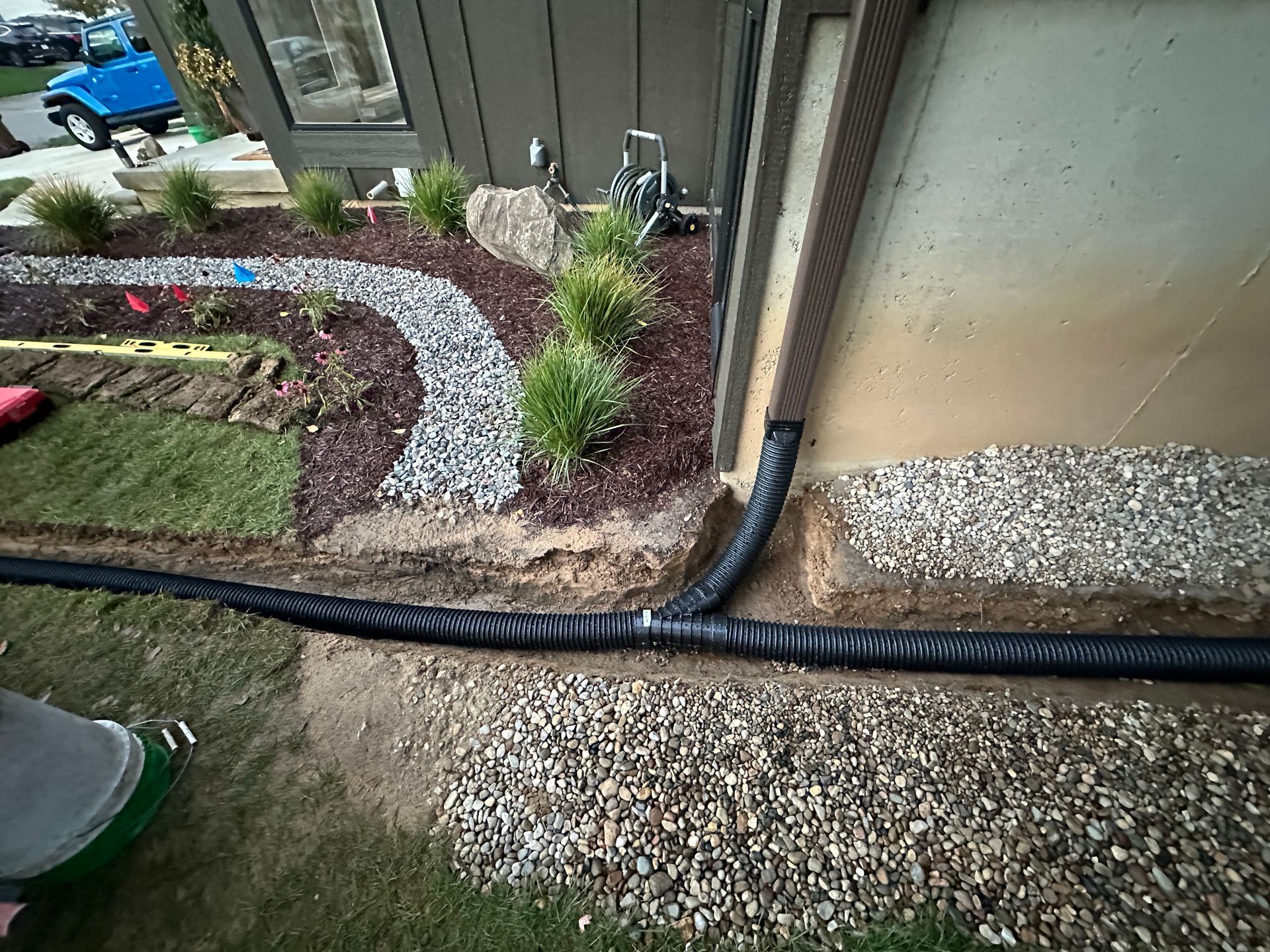 Y-drain installation connecting two downspout drains into one underground drainage line to redirect water away from a home in Haslett, Michigan
