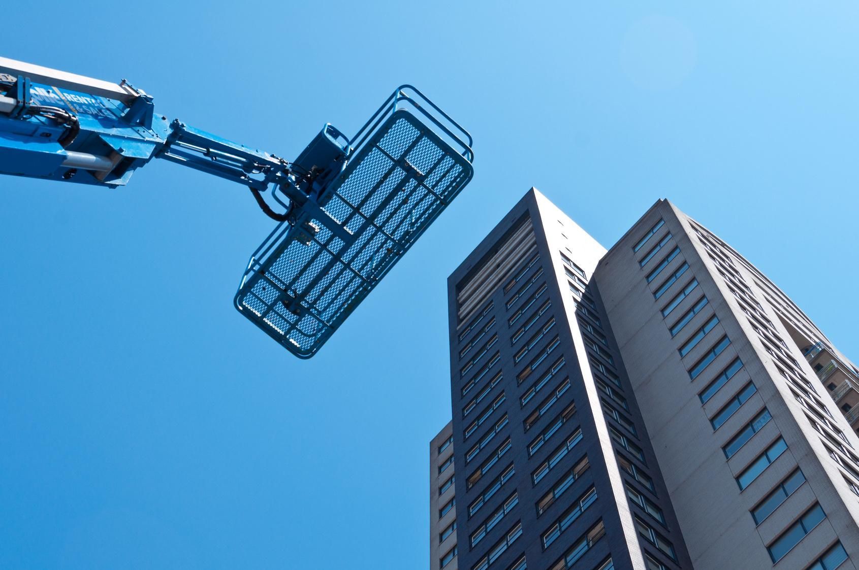 Una gru sta volando sopra un alto edificio.