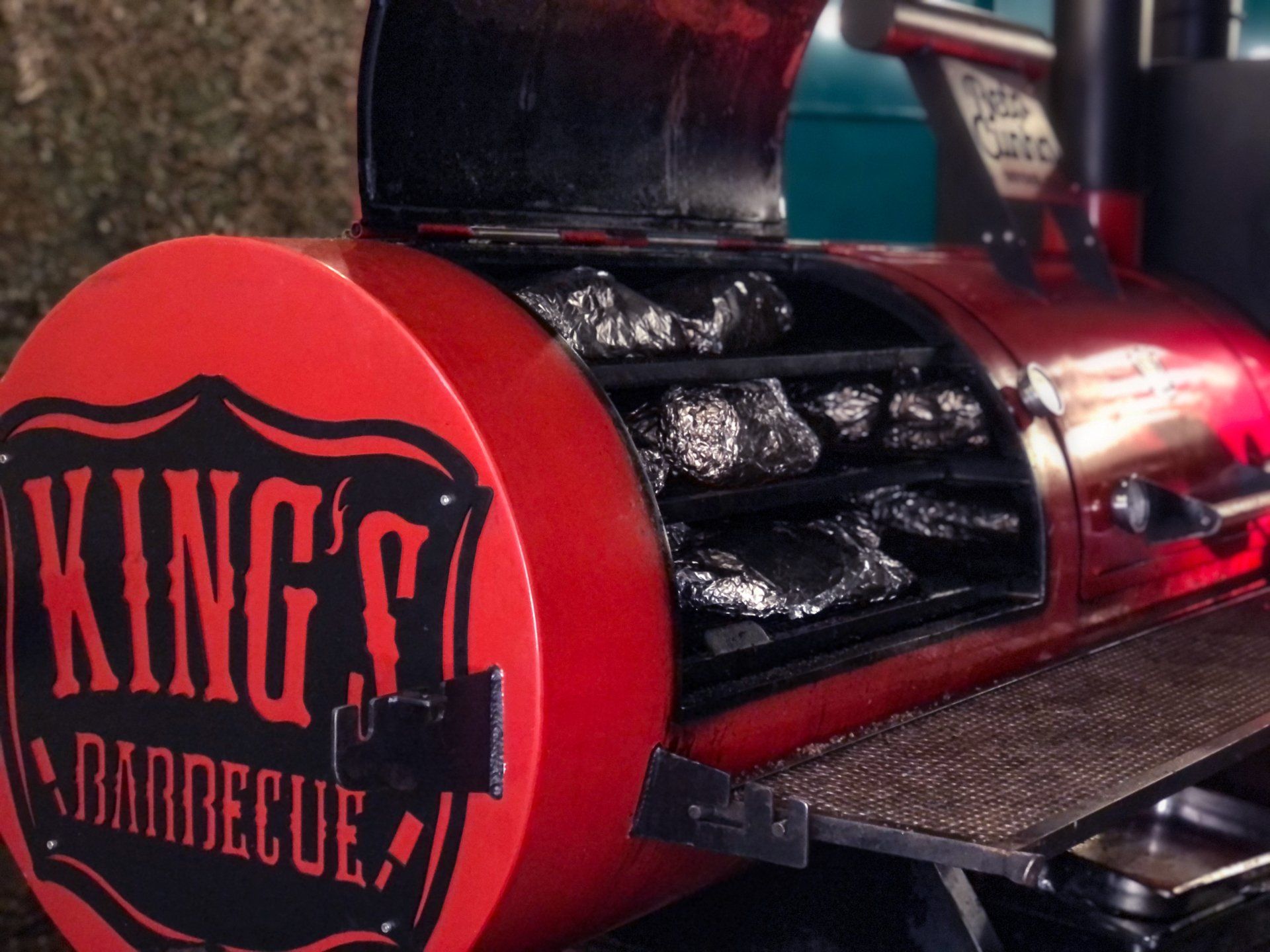 Defumador de churrasco Red King com prateleiras para alimentos embalados.