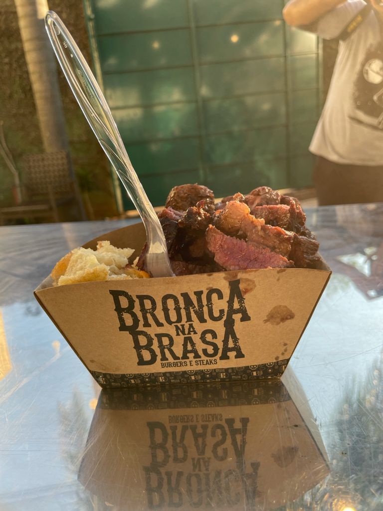 Um recipiente de papelão com comida grelhada e um garfo, etiquetado 