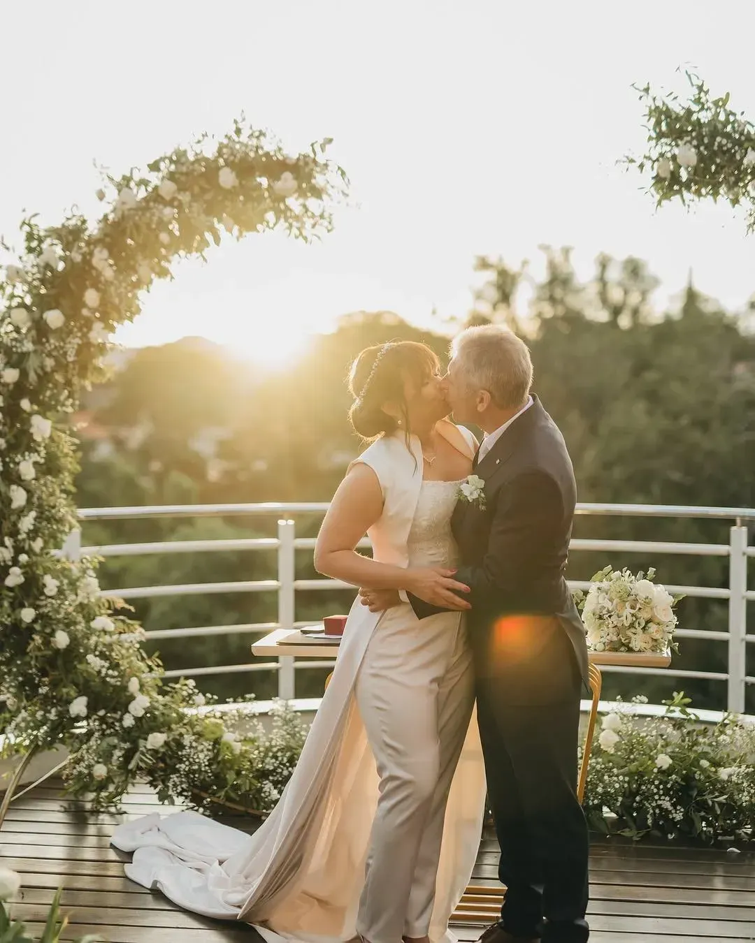 Saguão espaçoso e moderno com móveis brancos, janelas grandes e piso refletivo.
