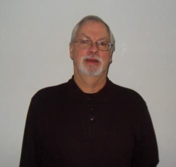 A man with glasses and a beard is wearing a black shirt