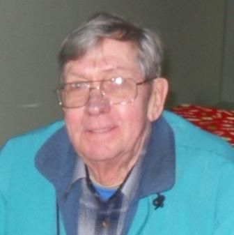 An older man wearing glasses and a blue jacket