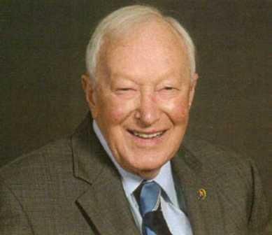 A man in a suit and tie is smiling for the camera.