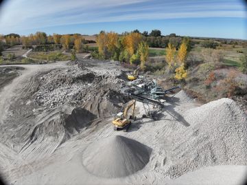 An aerial view of a construction site with a pile of dirt in the middle