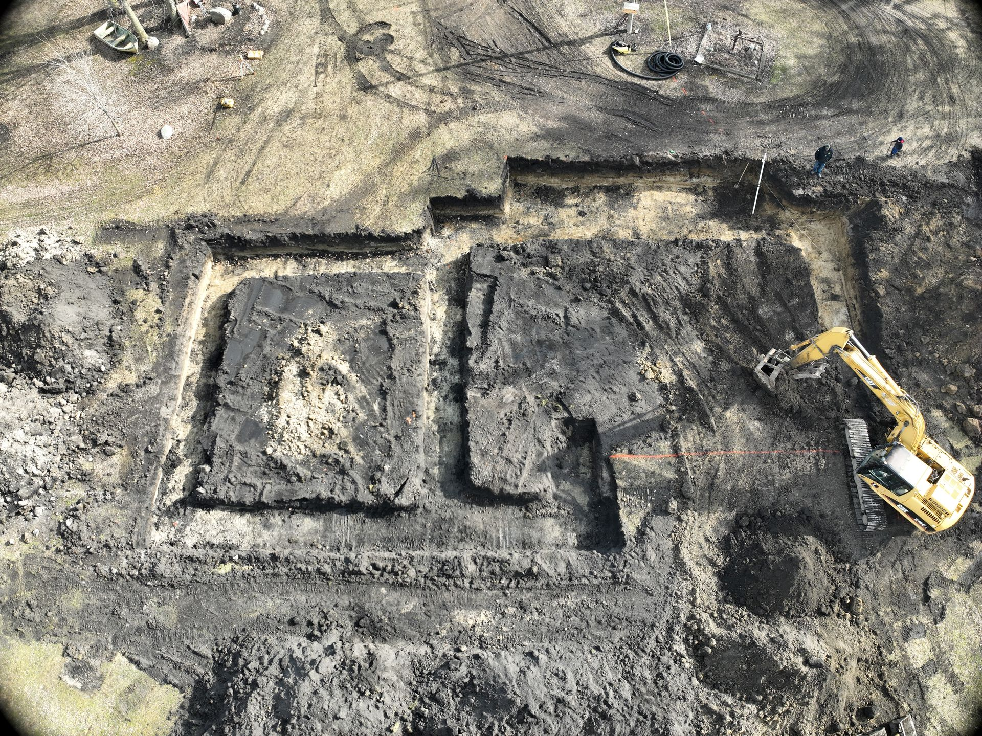 An aerial view of a dirt field with a house in the middle of it.