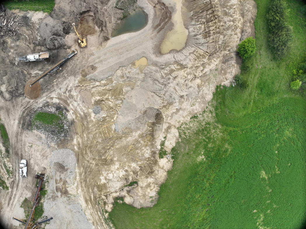 An aerial view of a construction site with a lot of dirt and grass.