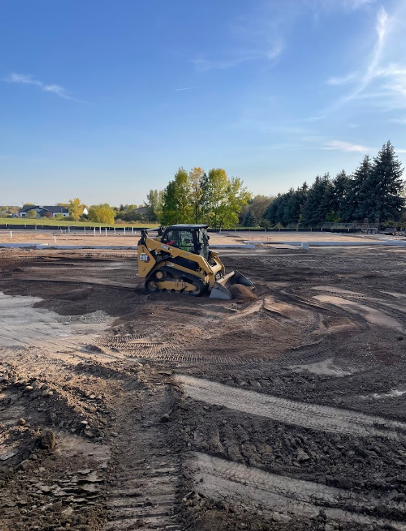 A large pile of dirt is being moved by a bulldozer.