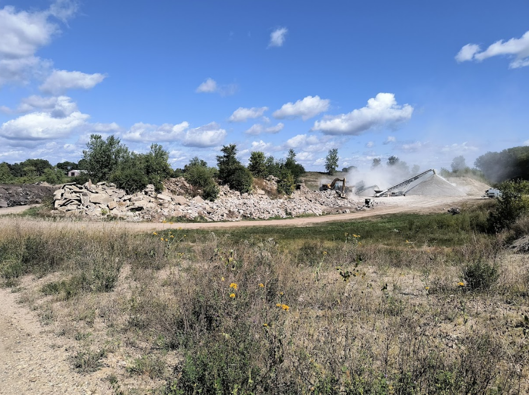 A large pile of dirt is sitting in the middle of a field.