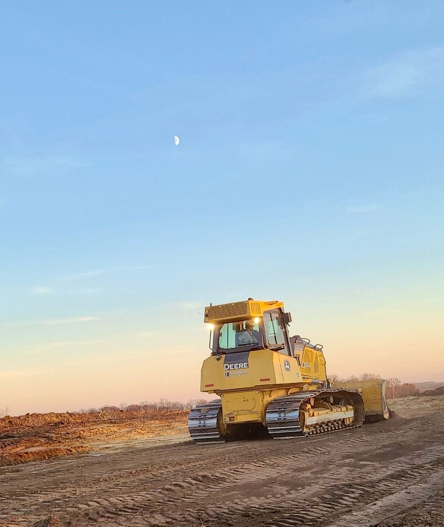 A bulldozer is driving down a dirt road.