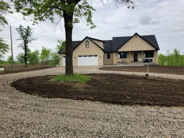 A house with a driveway and a tree in front of it
