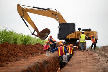 A group of construction workers are working on a road.