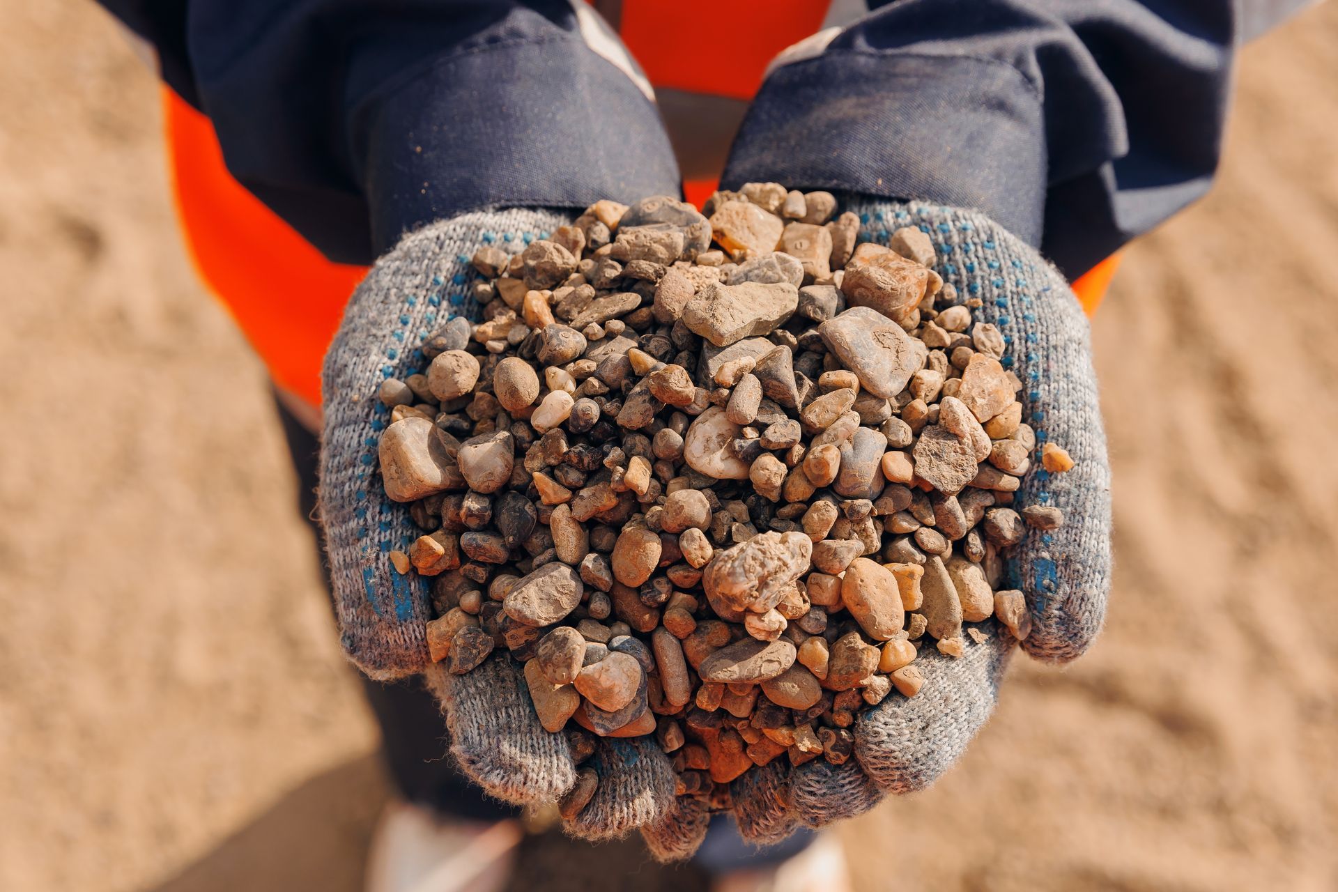A person is holding a pile of rocks in their hands.