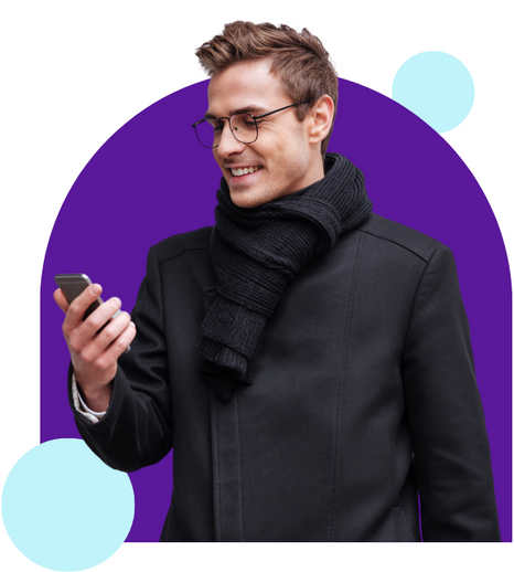 a man wearing glasses and a scarf is looking at his phone