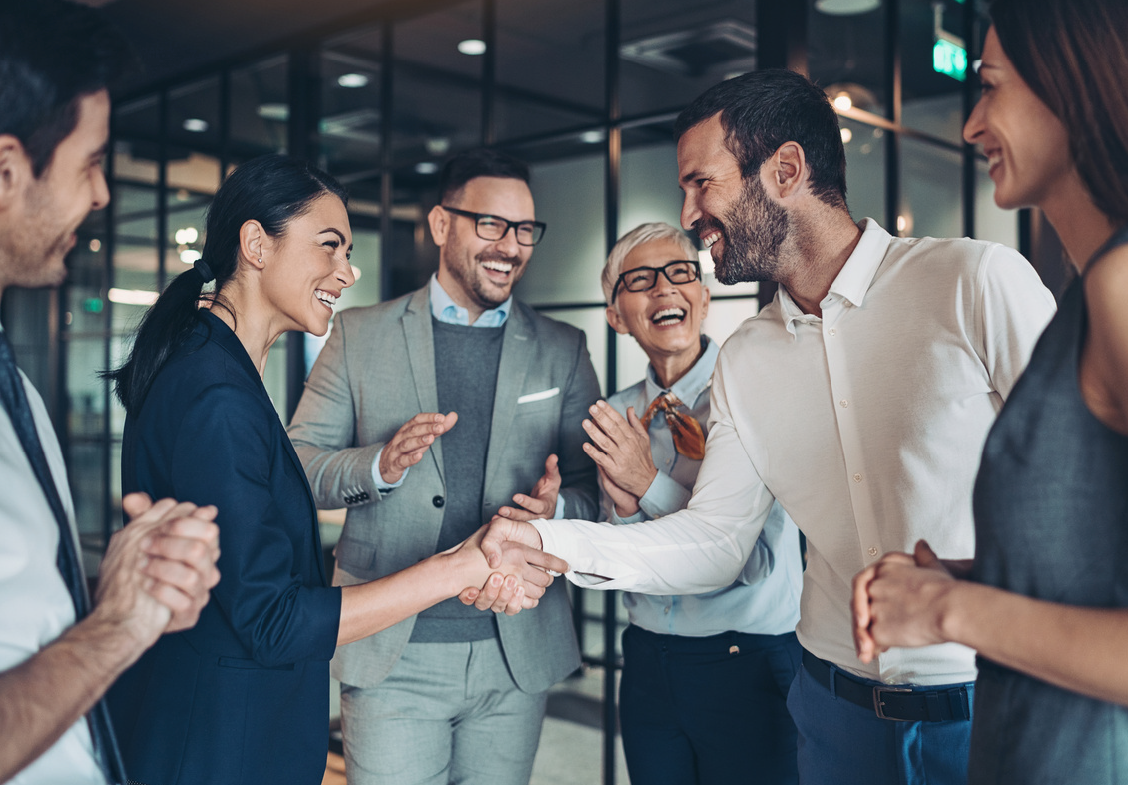 a group of business people are shaking hands in an office .