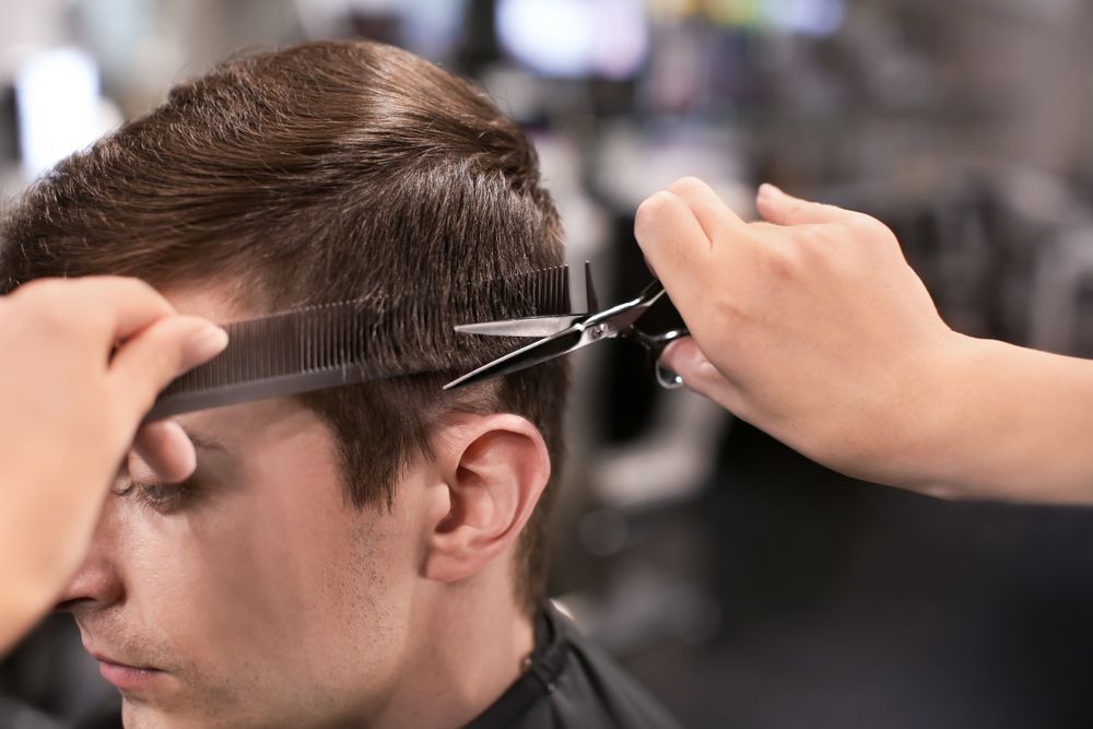 Hairdresser Cutting Client's Hair With Scissors and Comb in a Salon — The Gentleman's Barber QLD in Toowoomba City, QLD