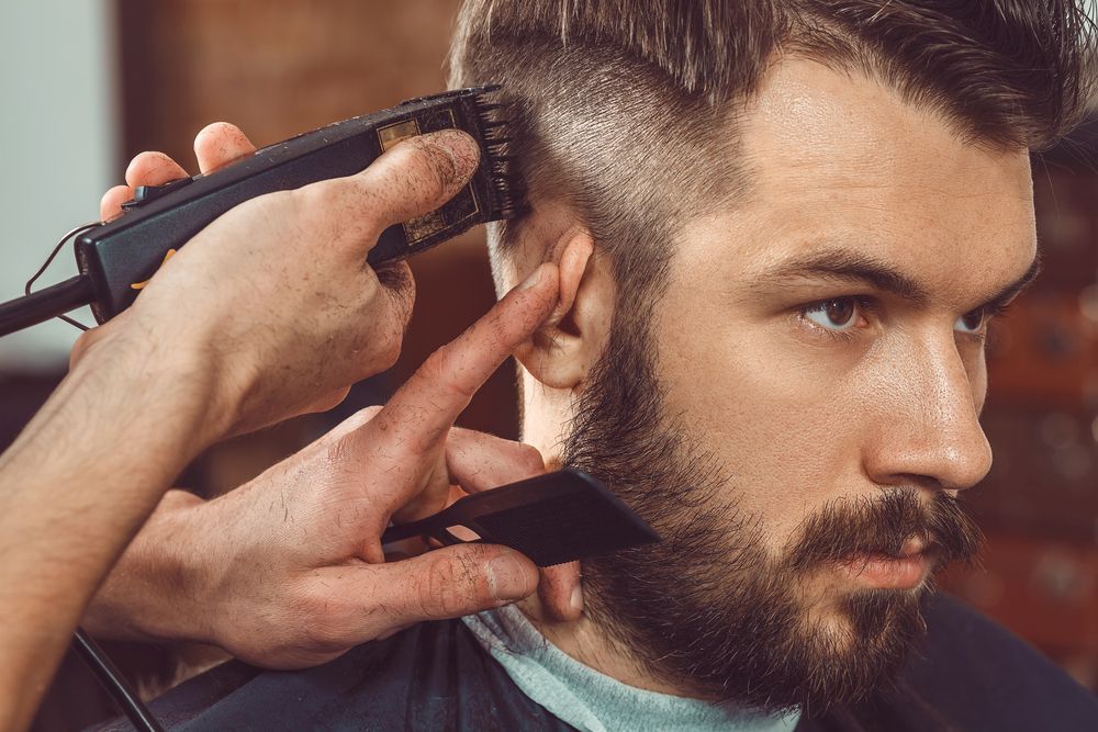 Barber Trimming a Man's Hair With Electric Clippers and a Comb in a Salon — The Gentleman's Barber QLD in Toowoomba City, QLD