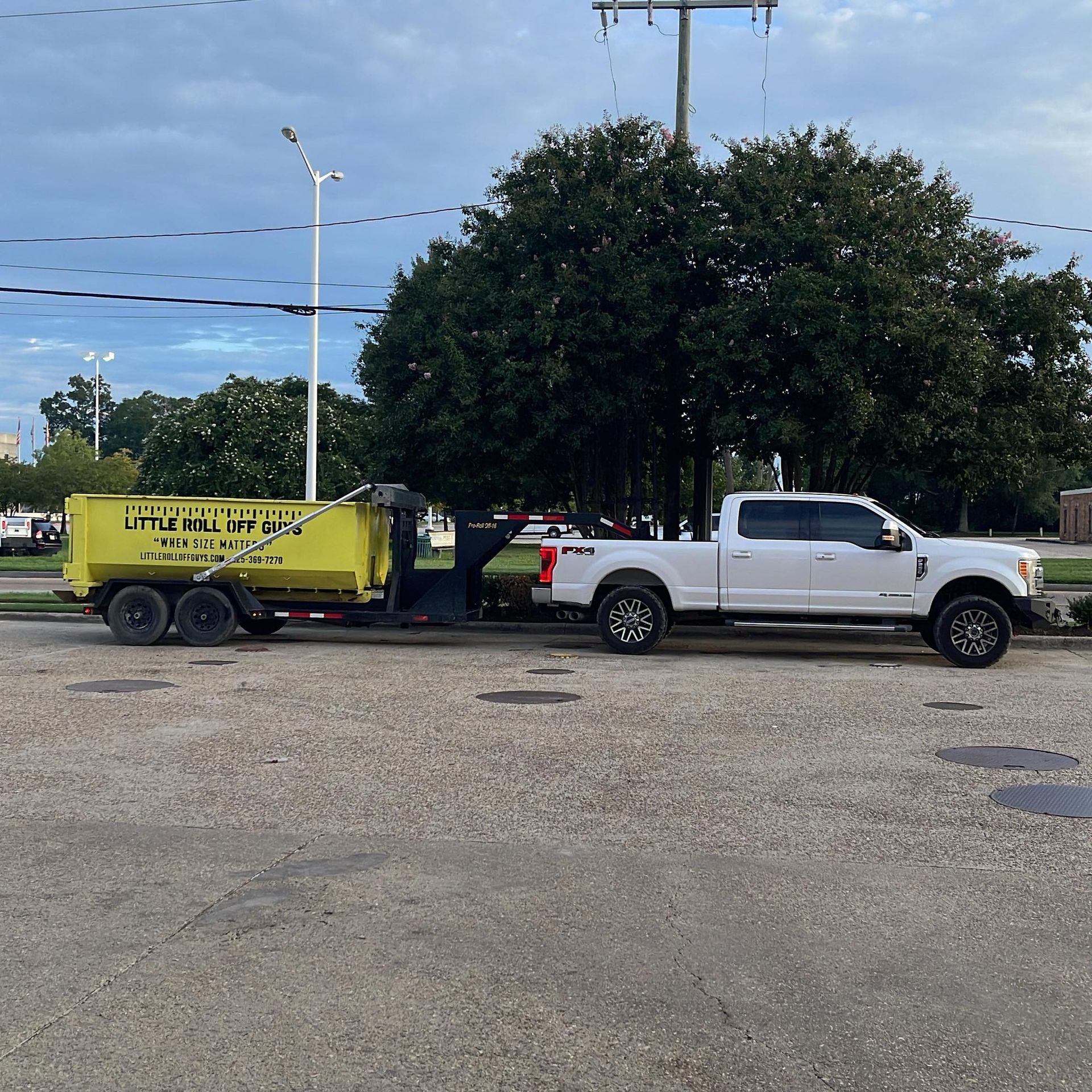 A white truck with a yellow dumpster attached to it