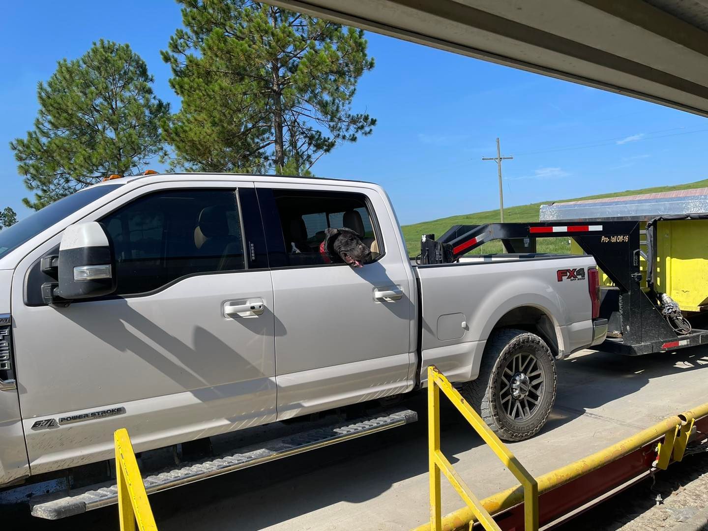 A white truck with a trailer attached to it is sitting on a scale.