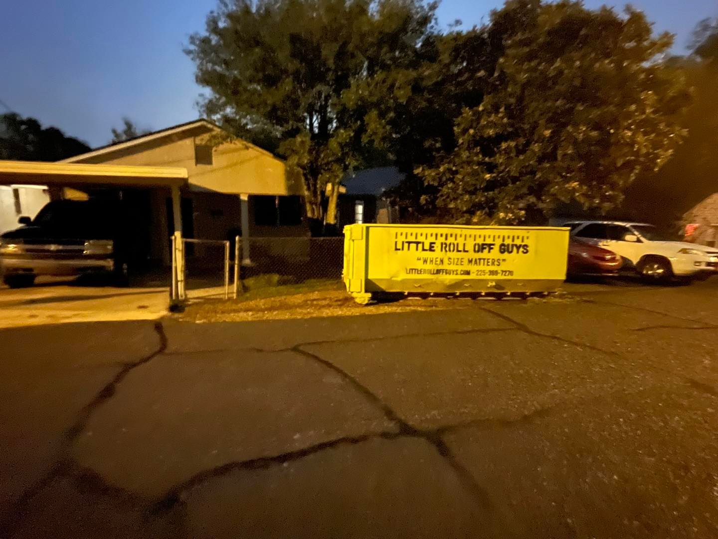 A yellow dumpster says little fall spy boys on it