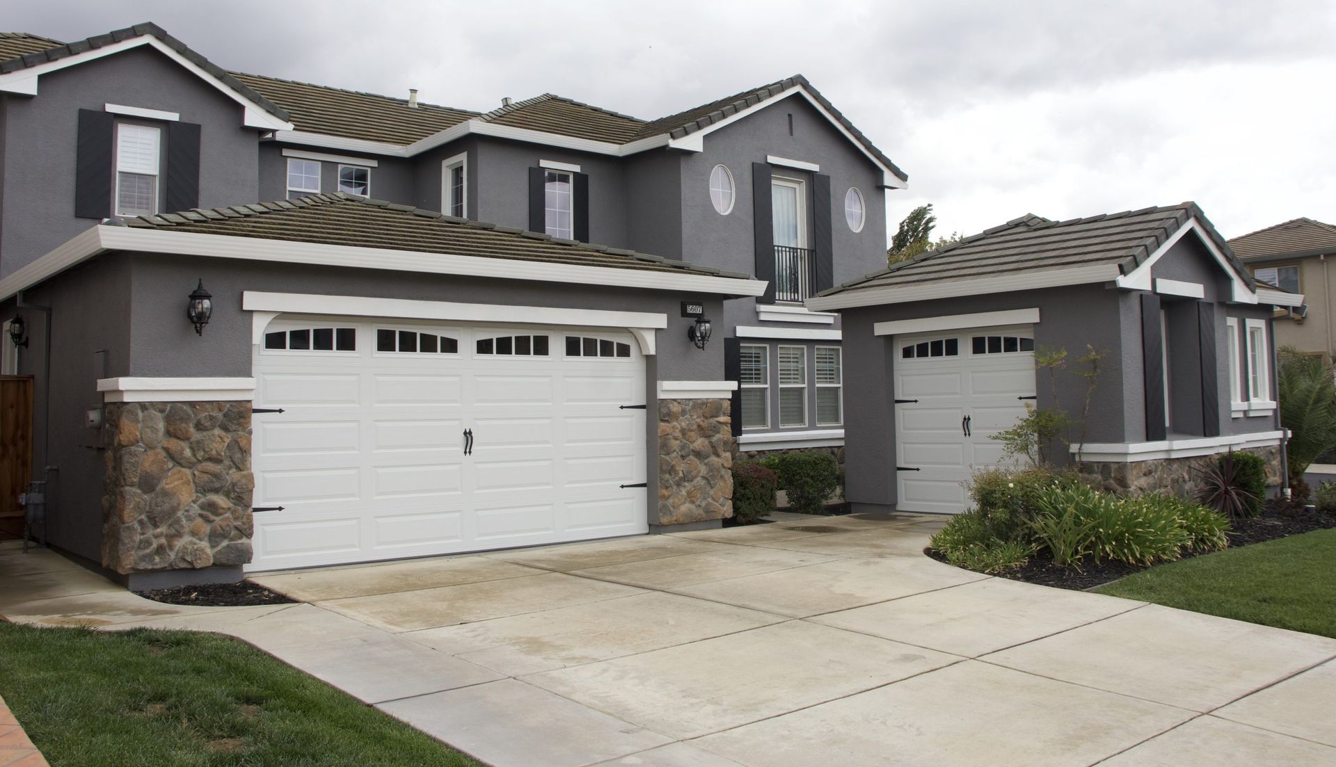 A large house with two garage doors and a driveway